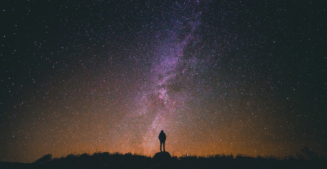 man standing amongst universe stars